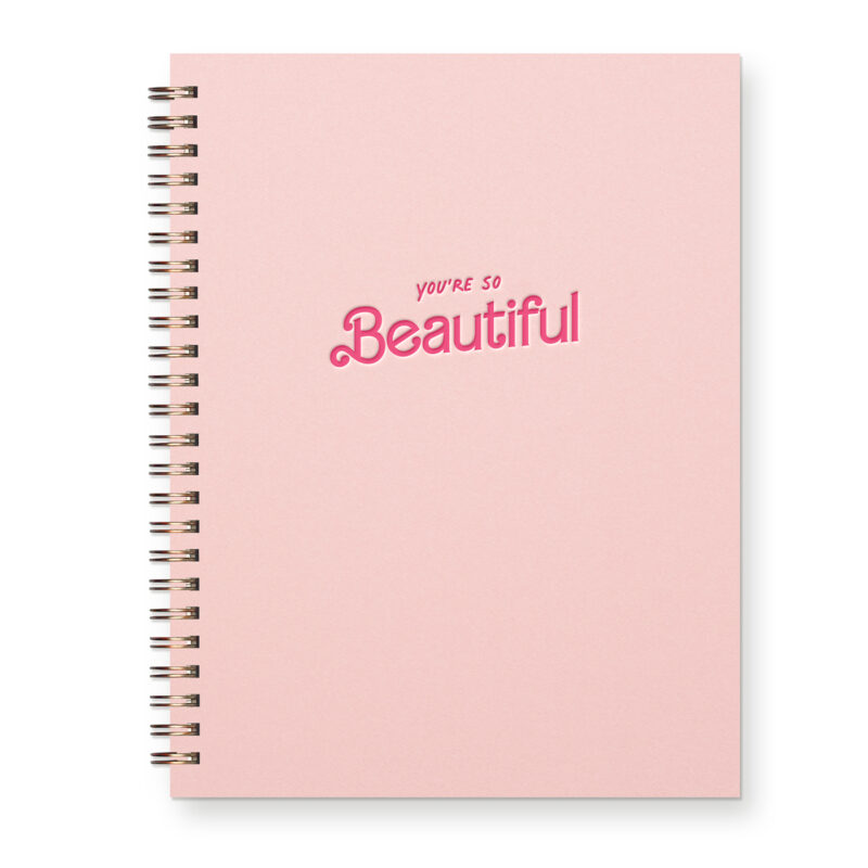 A light pink journal with the words "you're so beautiful" in hot pink