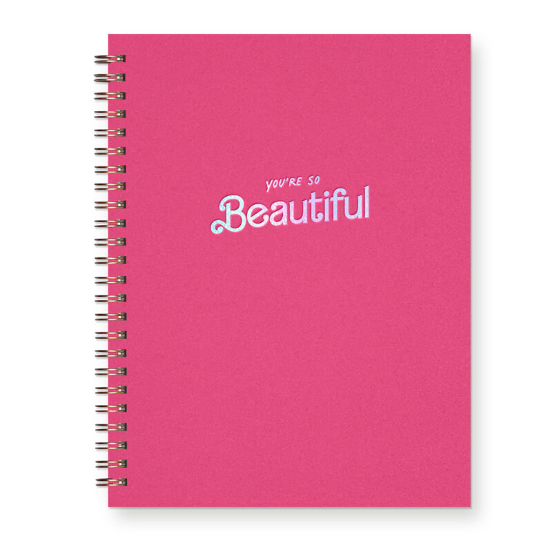 A hot pink journal with an iridescent foil design reading, "You're so beautiful"